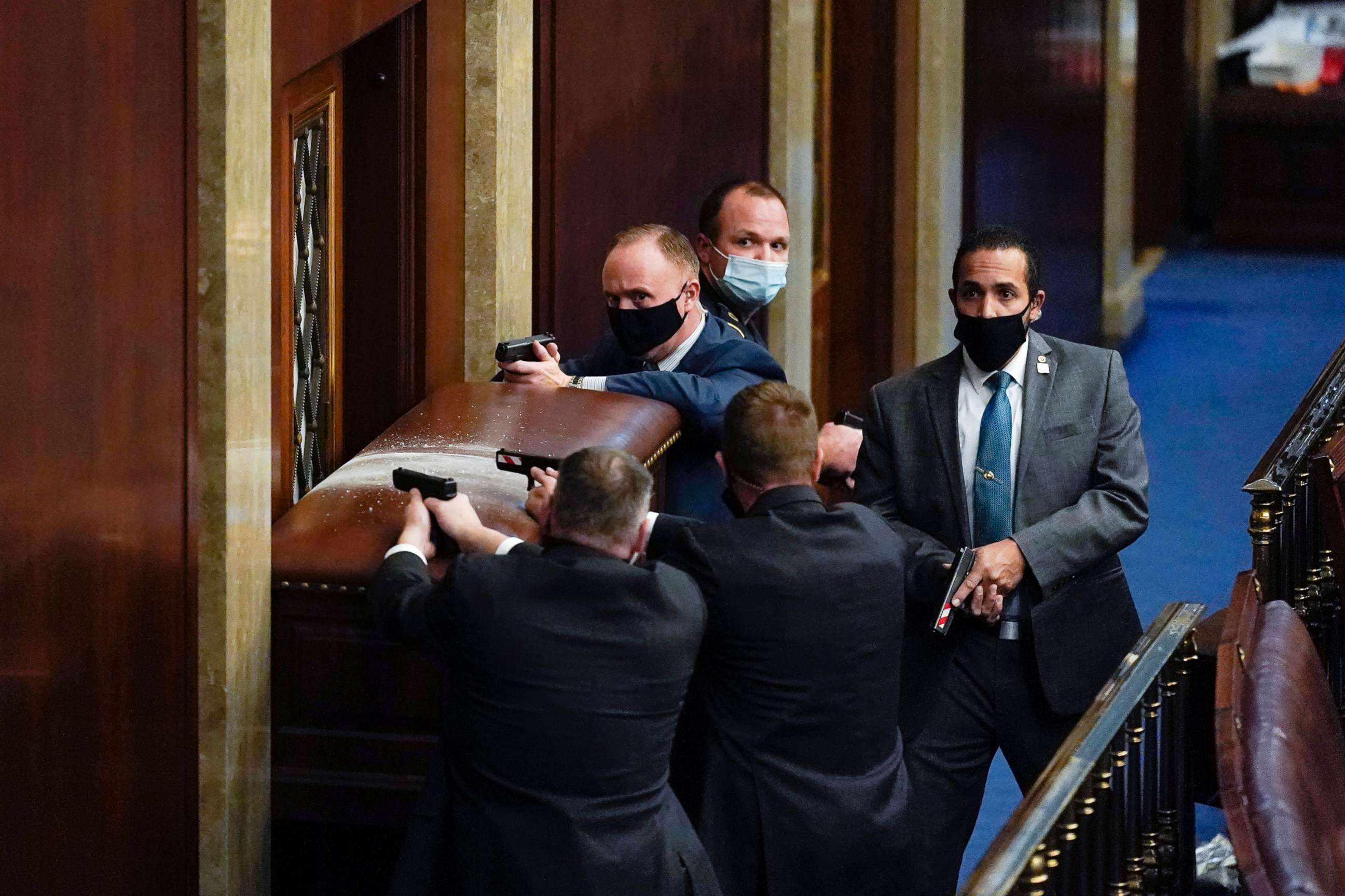 PHOTO: U.S. Capitol Police with guns drawn stand near a barricaded door as protesters try to break into the House Chamber at the U.S. Capitol, Jan. 6, 2021, in Washington, D.C.