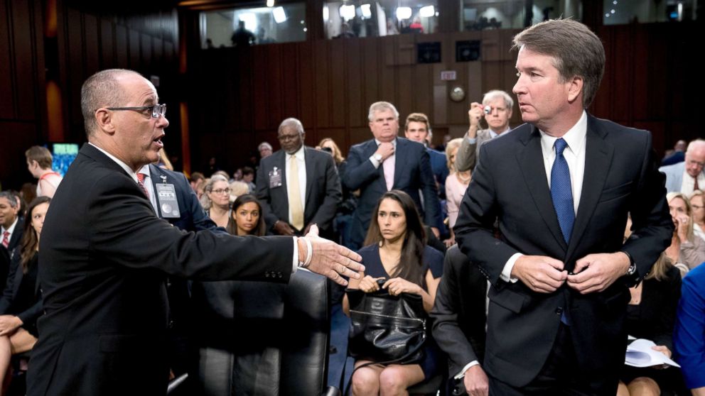 Fred Guttenberg, the father of Jamie Guttenberg who was killed in the Stoneman Douglas High School shooting in Parkland, Fla., left, attempts to shake hands with President Donald Trump's Supreme Court nominee, Brett Kavanaugh, right, as he leaves for a lunch break while appearing before the Senate Judiciary Committee on Capitol Hill in Washington, Sept. 4, 2018.