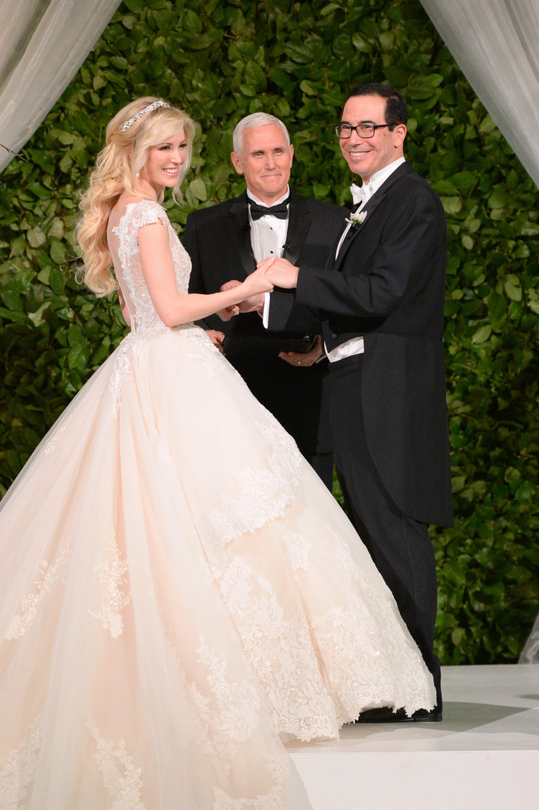 Vice President Mike Pence (C) officiates the wedding of  Louise Linton (L) and Secretary of the Treasury Steven Mnuchin (R) on June 24, 2017 at Andrew Mellon Auditorium in Washington, DC. 