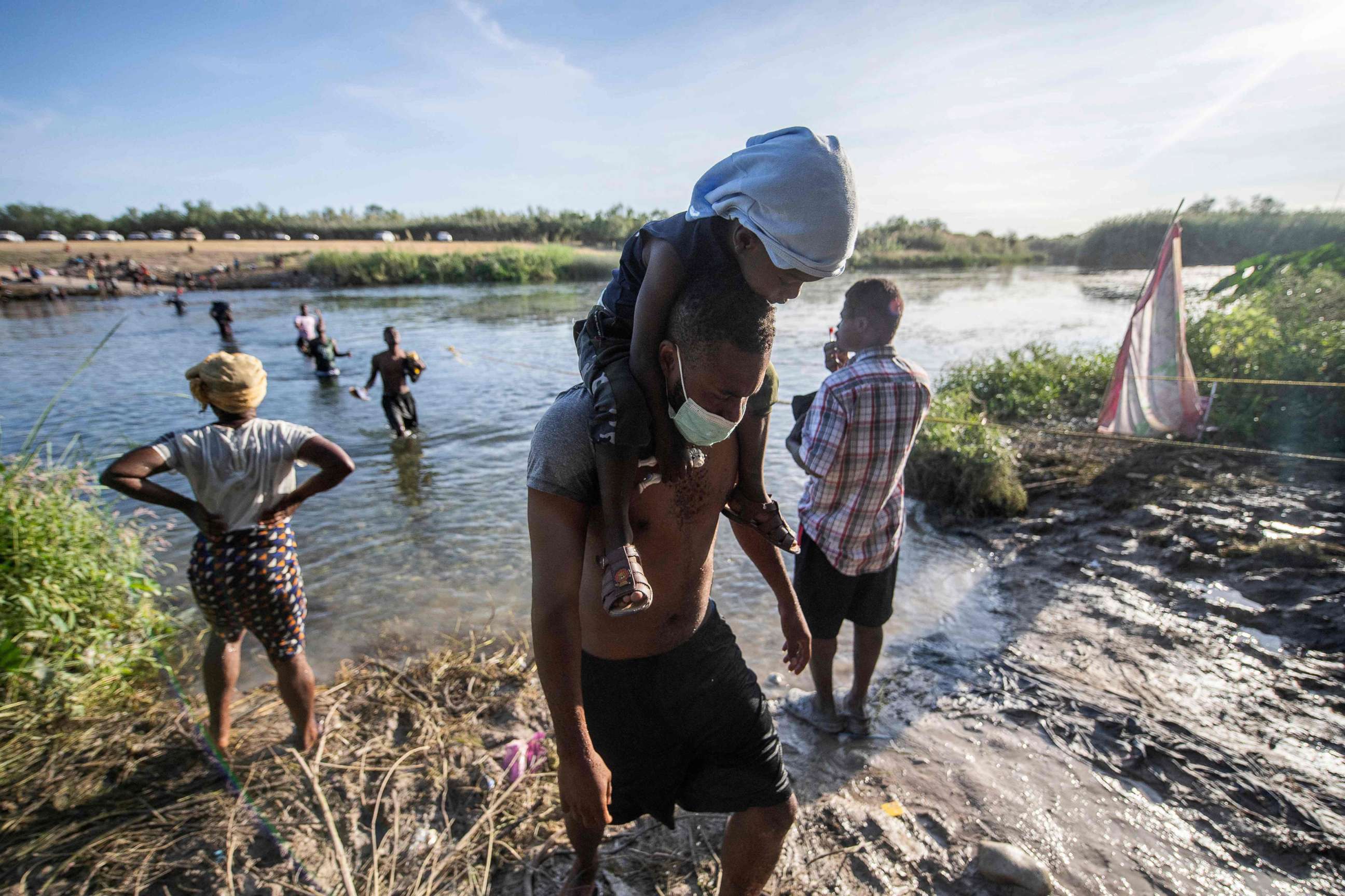 PHOTO: Haitian migrants cross the Rio Grande river to get food and water in Mexico, as seen from Ciudad Acuna, Coahuila state, Mexico on Sept. 22, 2021.