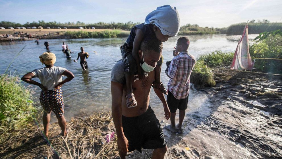 PHOTO: Haitian migrants cross the Rio Grande river to get food and water in Mexico, as seen from Ciudad Acuna, Coahuila state, Mexico on Sept. 22, 2021.