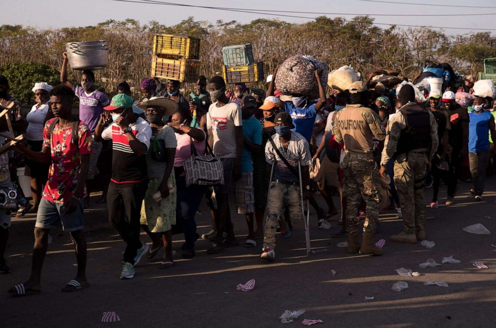 Dominican military agents control the passage of Haitian nationals from Ouanaminthe, Haiti, to Dajabon, Dominican Republic, after opening the gate on the bridge over the bordering Massacre River on March 5, 2021. 