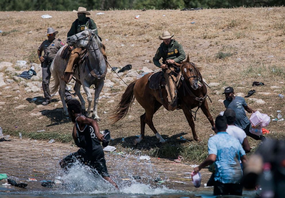 PHOTO: U.S. Customs and Border Protection mounted officers attempt to contain migrants as they cross the Rio Grande from Mexico into Del Rio, Texas, Sept. 19, 2021.