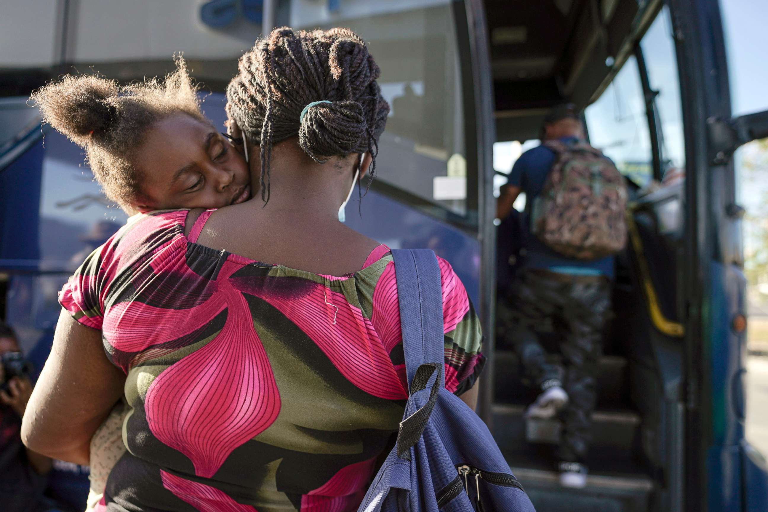 PHOTO: A child sleeps on the shoulder of a woman as they prepare to board a bus to San Antonio moments after a group of migrants, many from Haiti, were released from custody upon crossing the Texas-Mexico border, Sept. 22, 2021, in Del Rio, Texas.