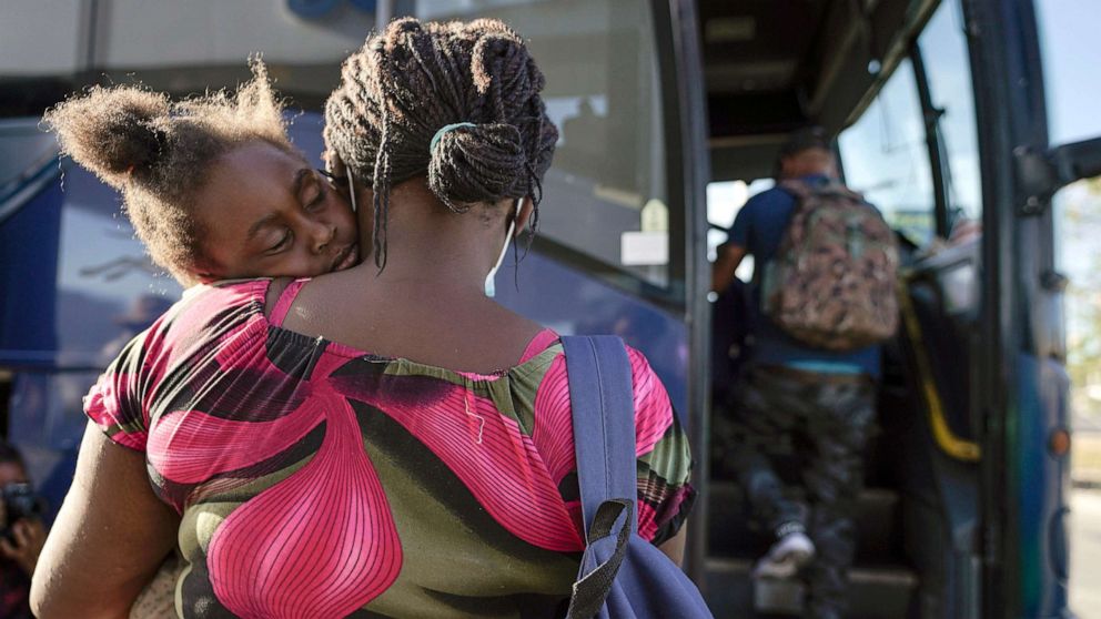 PHOTO: A child sleeps on the shoulder of a woman as they prepare to board a bus to San Antonio moments after a group of migrants, many from Haiti, were released from custody upon crossing the Texas-Mexico border, Sept. 22, 2021, in Del Rio, Texas.