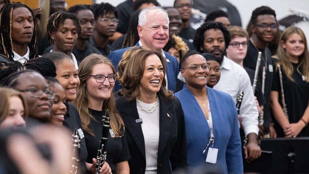 PHOTO: Democratic presidential candidate Vice President Kamala Harris and her running mate, Governor Tim Walz, pose with members of the marching band during a visit at Liberty County High School in Hinesville, Georgia,  Aug. 28, 2024.