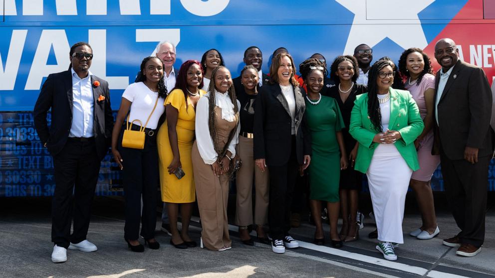 PHOTO: Democratic presidential candidate US Vice President Kamala Harris and her running mate, Minnesota Governor Tim Walz, pose with supporters in front of their campaign bus at Savannah Hilton Head International Airport, Aug. 28, 2024, in Savannah, Ga.