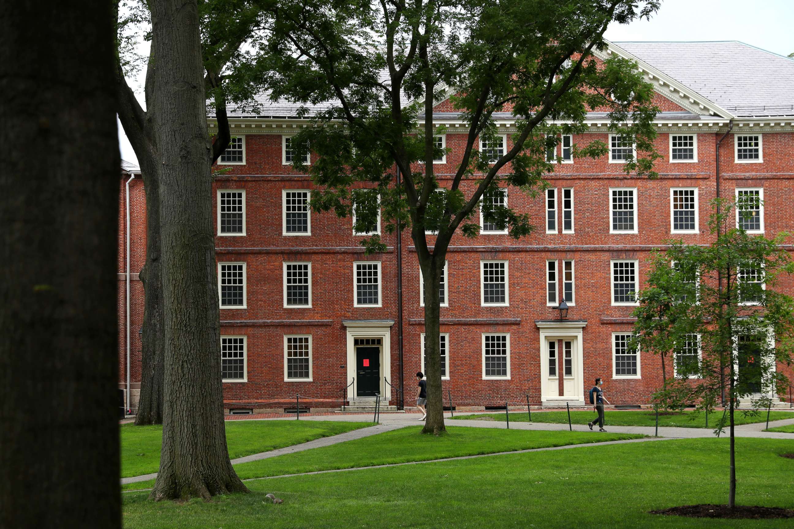 PHOTO: People walk across Harvard Yard on the campus of Harvard University on July 08, 2020, in Cambridge, Mass.