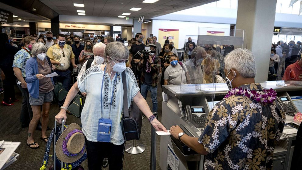 PHOTO: Travelers wearing protective masks board a United Airlines Holdings Inc. flight to Hawaii at San Francisco International Airport (SFO) in San Francisco, Oct. 15, 2020. 