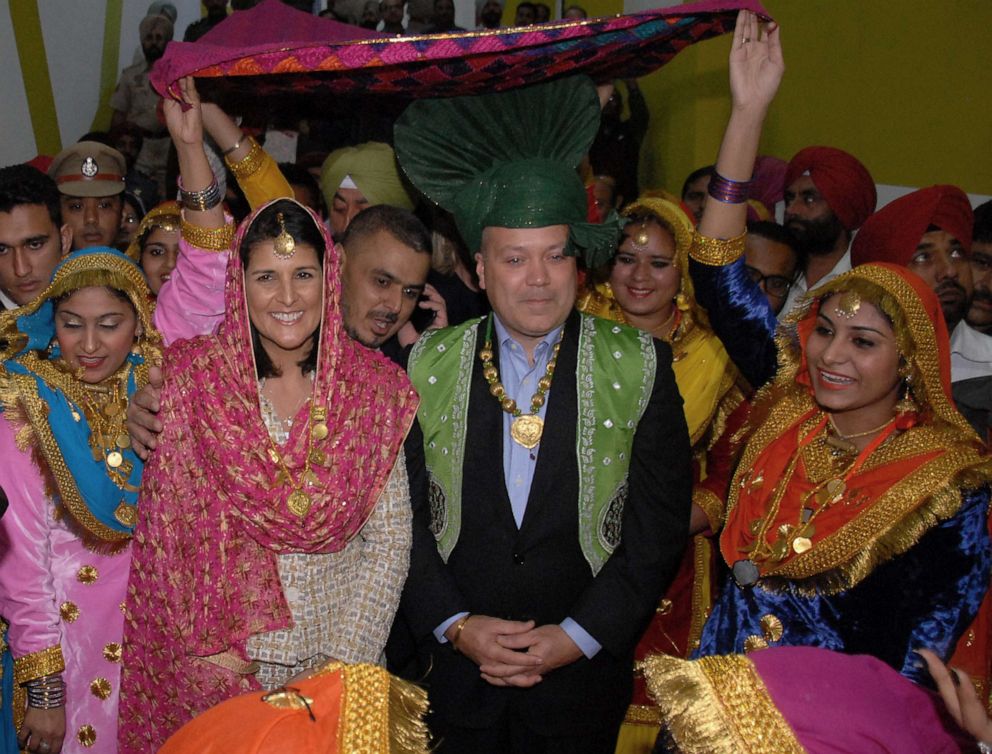PHOTO: Governor of South Carolina Nikki Haley poses with her husband Michael Haley and traditional Punjabi dancers as she arrives to attend a function at Lovely Professional University LPU in Jalandhar, Nov. 14, 2014.