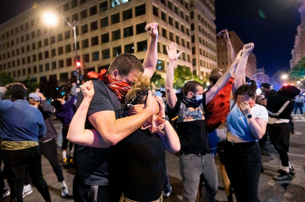 PHOTO: Protesters holds their hands up and try to steady themselves as a military helicopter flies low, pushing rotor wash onto the crowd during a protest over the death of George Floyd, June 1, 2020, in Washington, D.C. 