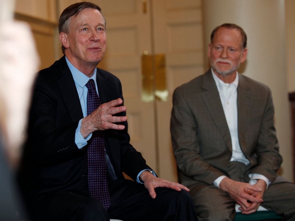 PHOTO: Democratic presidential hopeful John Hickenlooper, left, speaks as Michael Davis, back, looks on during a meeting with survivors of victims of mass shootings in Colorado Tuesday, April 16, 2019, in Denver.
