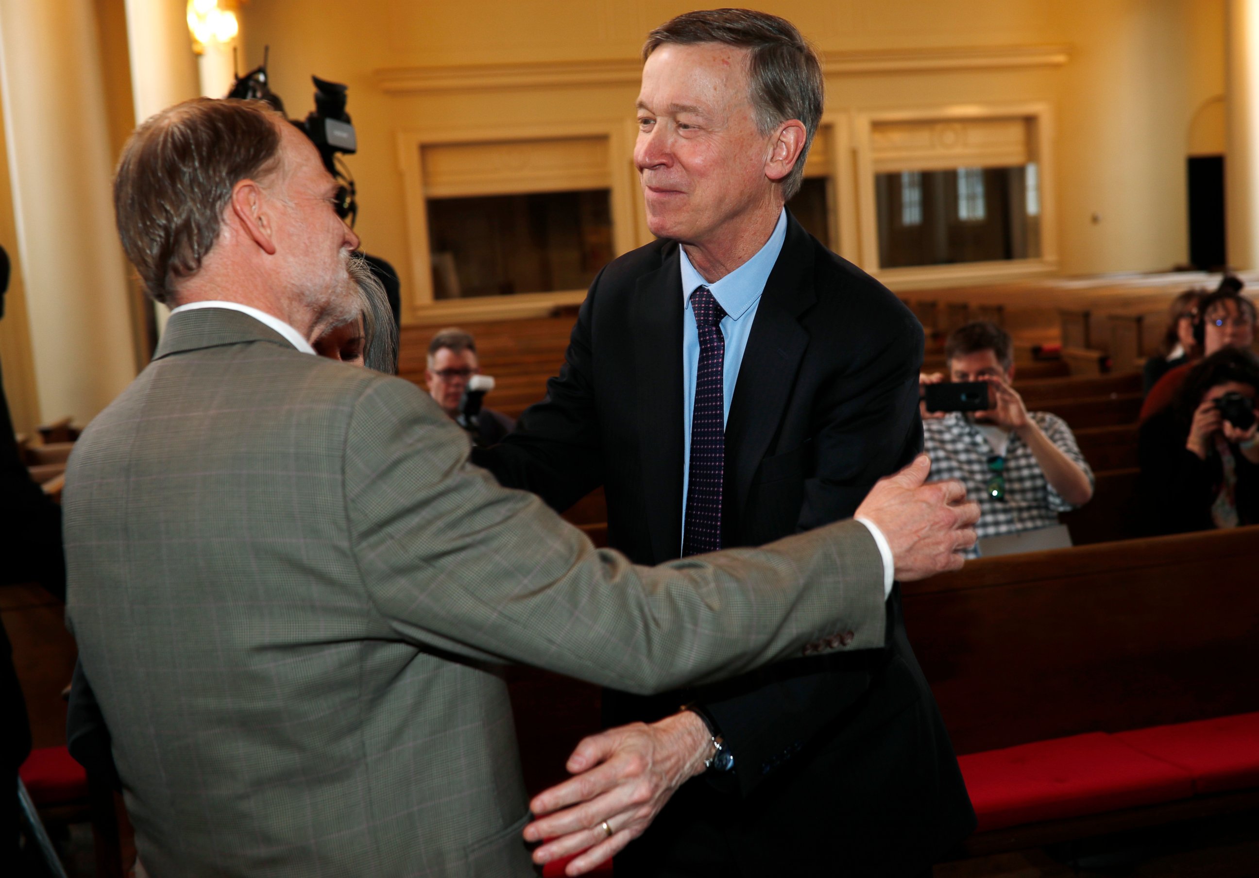 PHOTO: Democratic presidential hopeful John Hickenlooper, right, hugs Michael Davis during a meeting with survivors of victims of mass shootings in Colorado Tuesday, April 16, 2019, in Denver.