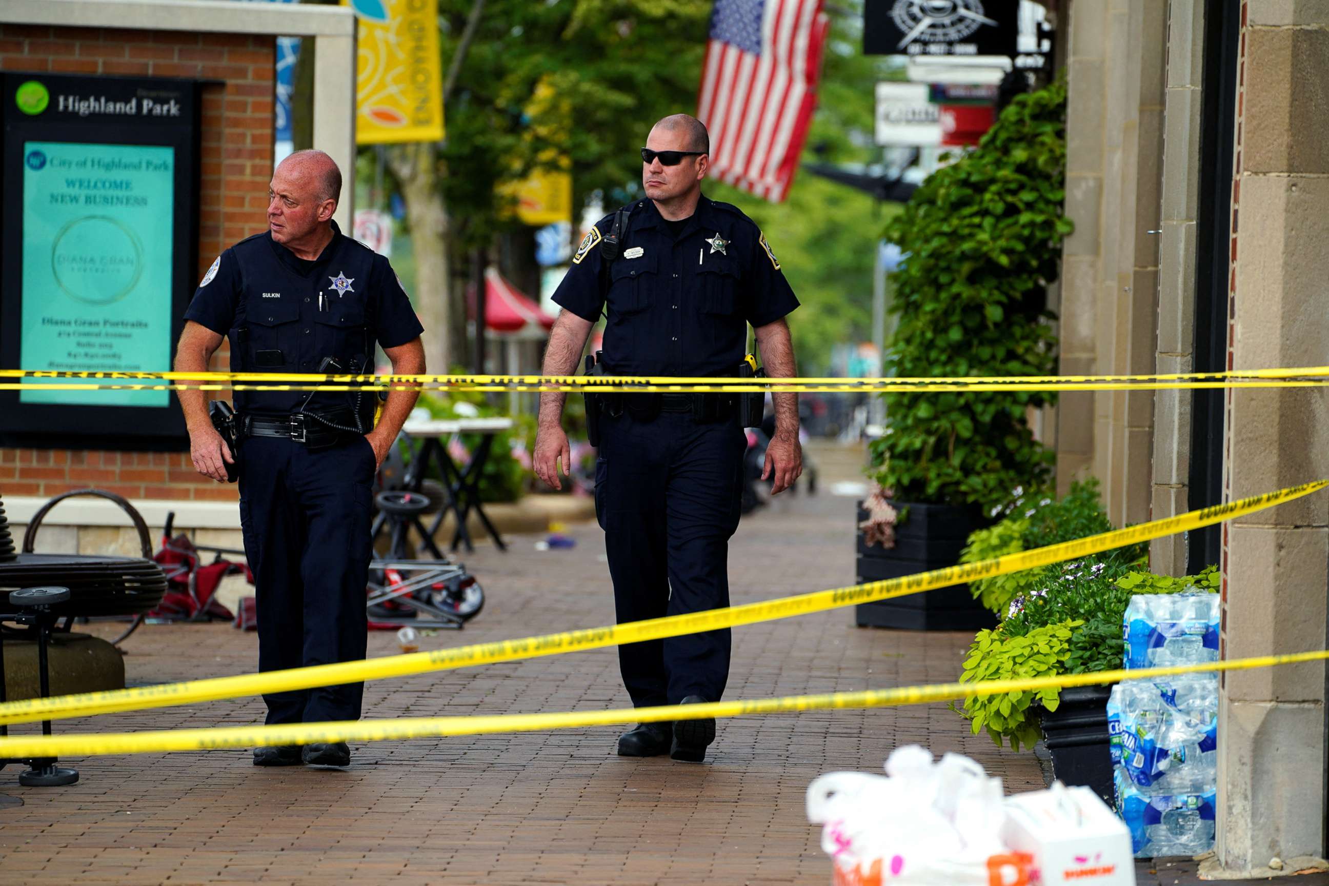 PHOTO: Police officers walk through the crime scene the day after a mass shooting at a Fourth of July parade in the wealthy Chicago suburb of Highland Park, Ill., July 5, 2022.