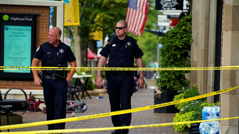 PHOTO: Police officers walk through the crime scene the day after a mass shooting at a Fourth of July parade in the wealthy Chicago suburb of Highland Park, Ill., July 5, 2022.