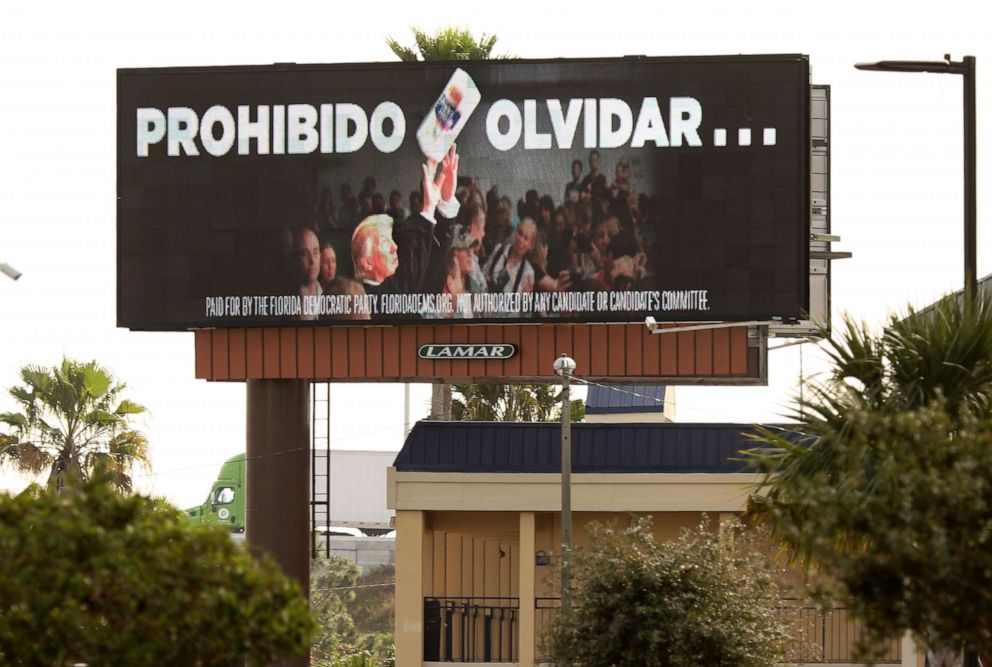 PHOTO: An electronic billboard ad paid for by the Florida Democratic Party reading "Never Forget" (in Spanish) and showing President Donald Trump throwing a roll of paper towels is seen along the Florida Turnpike in Kissimmee, Fla. on Jan. 16, 2020. 