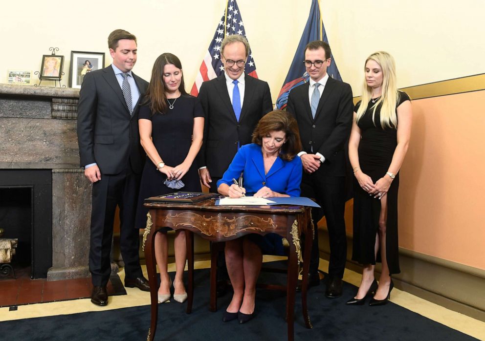 PHOTO: Matthew Gloudeman, Caitlin Hochul, Bill Hochul, William Hochul and Christina Hochul watch as New York Gov. Kathy Hochul signs documents at her swearing-in in the Red Room at the state Capitol on August 24, 2021 in Albany, New York.