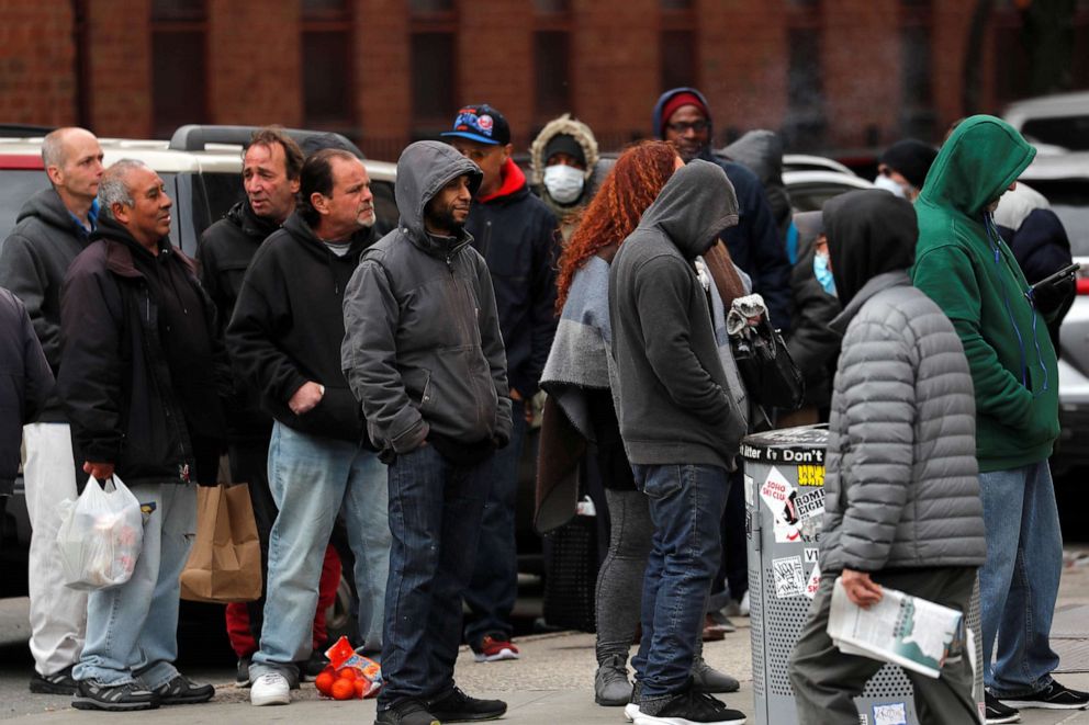 PHOTO: Homeless and other needy people crowd together as they wait in a long line for a free meal outside The Bowery Mission on the lower east side of New York during the coronavirus outbreak, March 25, 2020. 