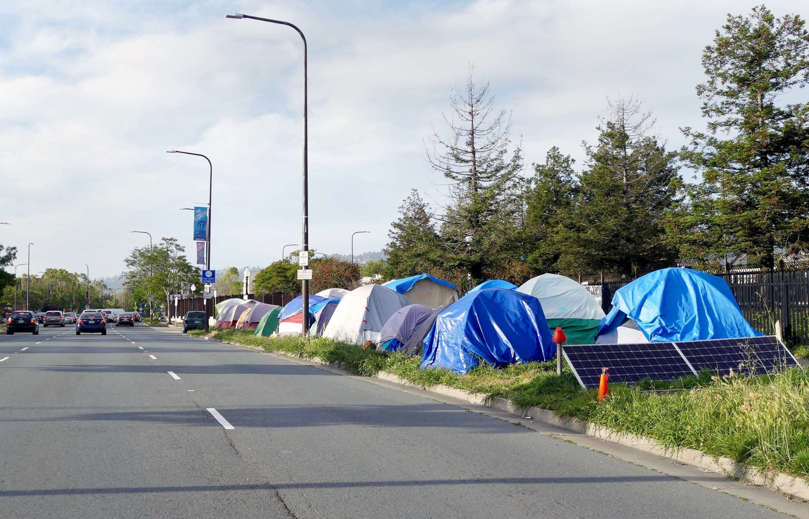 PHOTO: Cars drive past the a homeless encampment along a street in Berkeley, Calif., May 22, 2019.