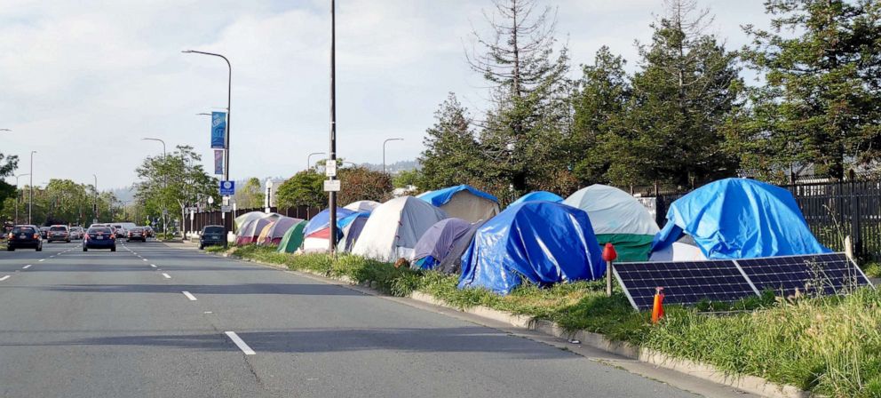 PHOTO: Cars drive past the a homeless encampment along a street in Berkeley, Calif., May 22, 2019.