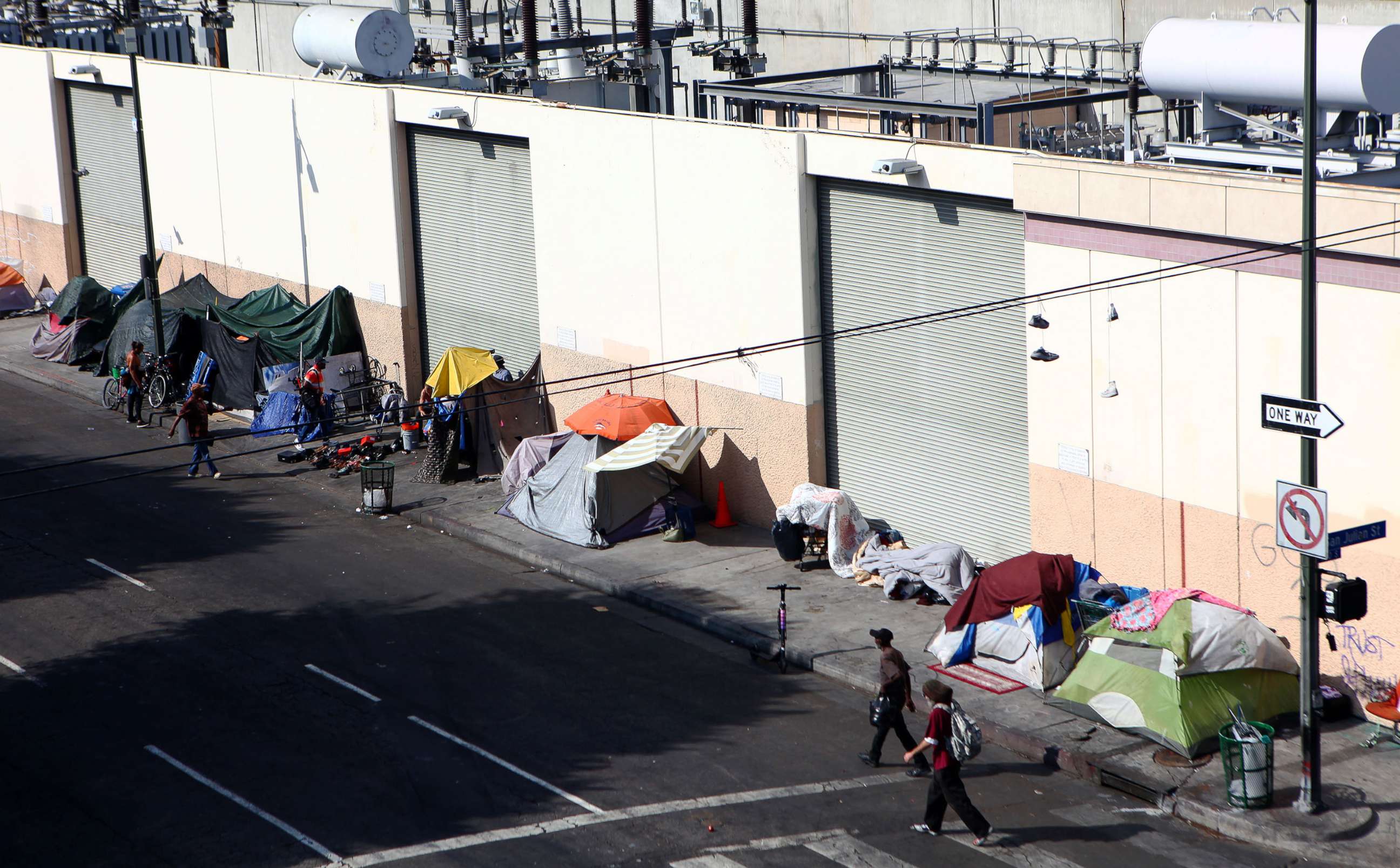 PHOTO: People walk past a homeless tent encampment in Skid Row, Sept. 16, 2019, in Los Angeles.