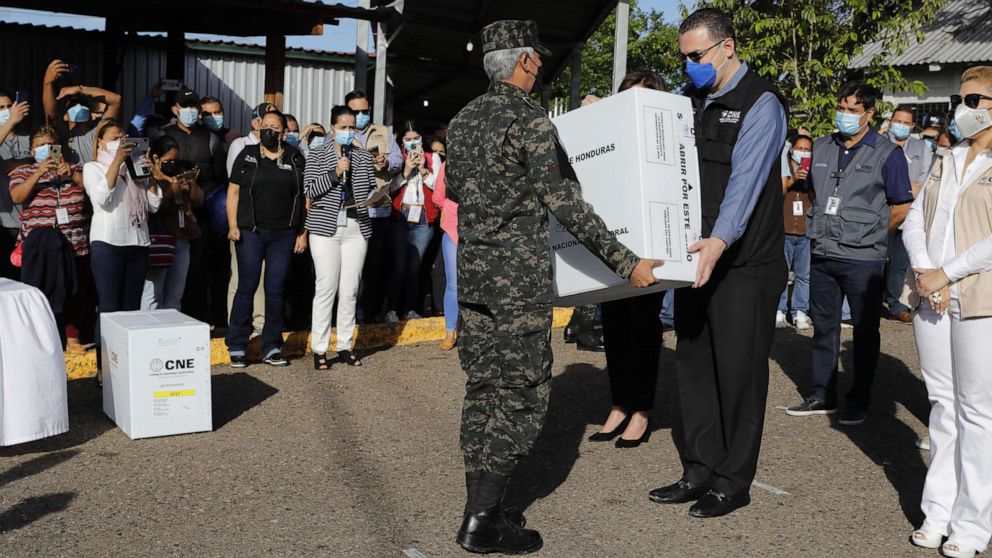 PHOTO: The president of the National Electoral Council of Honduras, Kevin Izaguirre (R), and the Chief of the Armed Forces of that country, Tito Livio Moreno, carry a box with electoral material for the elections in Tegucigalpa, Honduras, Nov. 23, 2021.