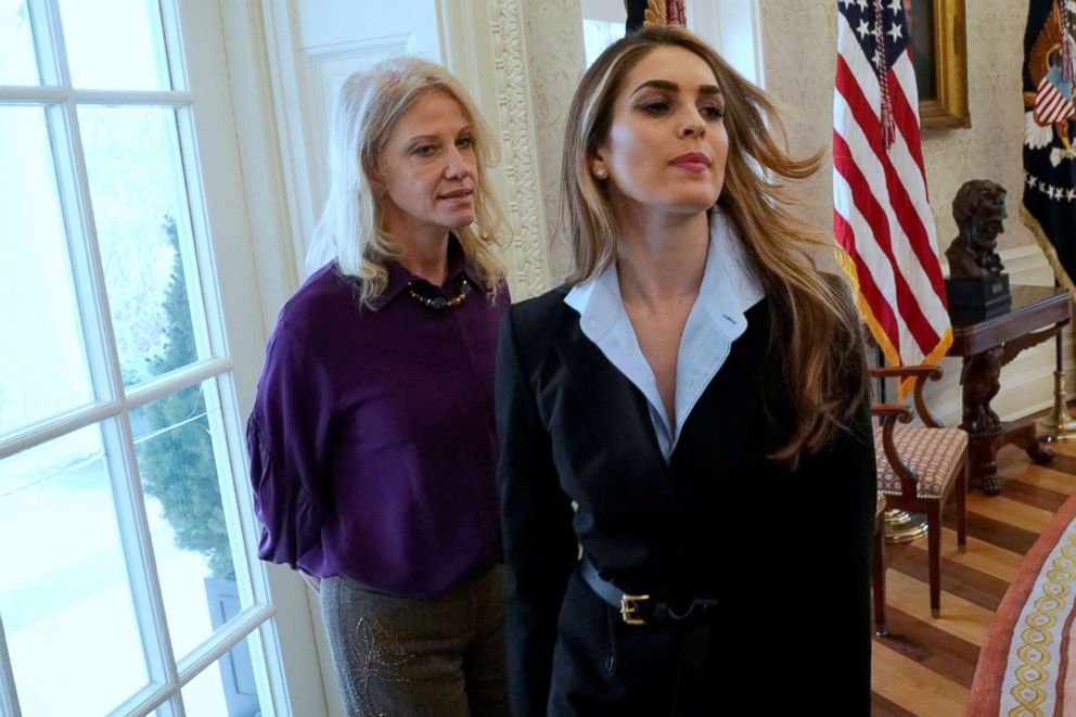 PHOTO: White House Communications Director Hope Hicks (C) departs as she and White House counselor Kellyanne Conway (L) while President Donald Trump speaks to reporters in the Oval Office at the White House, Feb. 9, 2018.  