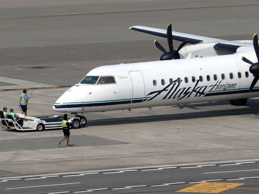 PHOTO: A Horizon Air Q400 turboprop aircraft, owned by Alaska Air Group, is installed by airport employees at the Seattle-Tacoma International Airport in SeaTac, Washington on August 13, 2018.