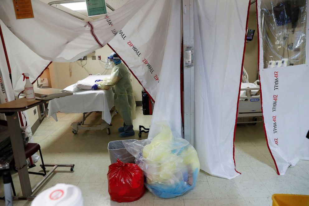 PHOTO: A hospital housekeeper at Roseland Community Hospital disinfects the room where a COVID-19 patient died in Chicago, Dec. 1, 2020.