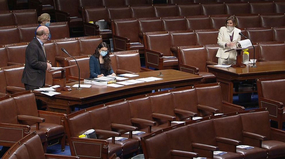 PHOTO: House Speaker Nancy Pelosi listens to Rep. James McGovern ahead of a vote on a $484 billion coronavirus relief bill on the floor of the House of Representatives in Washington, AprIl 23, 2020.