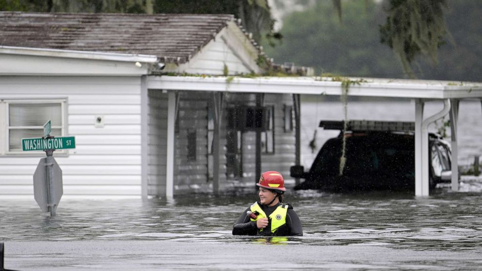 PHOTO: A first responder with Orange County Fire Rescue makes her way through floodwaters looking for residents of a neighborhood needing help in the aftermath of Hurricane Ian in Orlando, FLa., Sept. 29, 2022.
