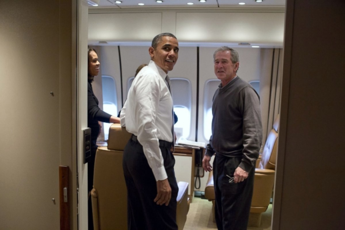 President Barack Obama jokes with former President George W. Bush shortly after boarding Air Force One for the trip to South Africa, Dec. 9, 2013. 