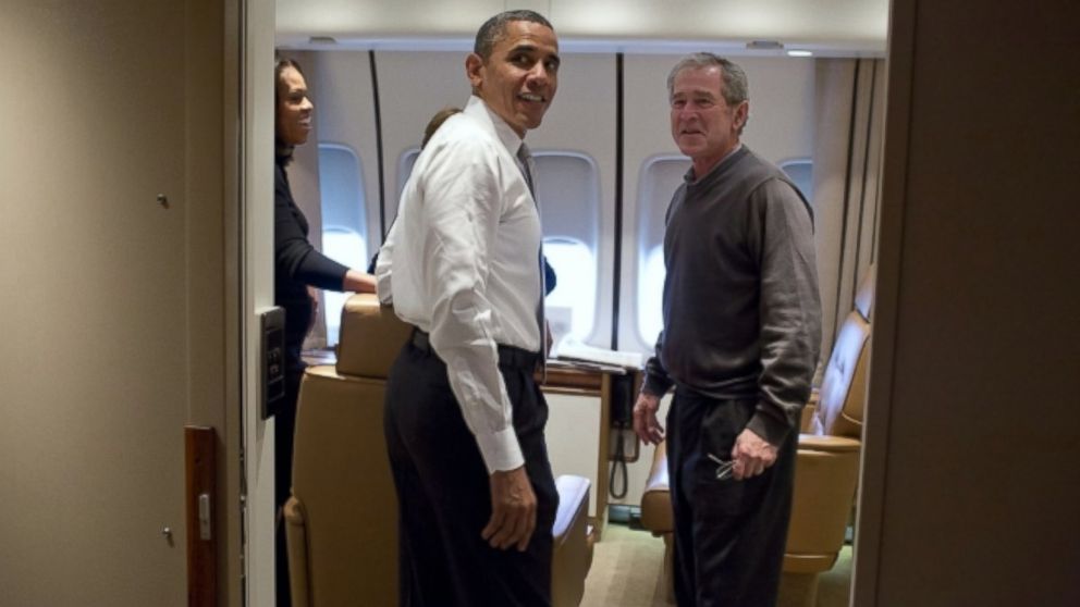 President Barack Obama jokes with former President George W. Bush shortly after boarding Air Force One for the trip to South Africa, Dec. 9, 2013. 