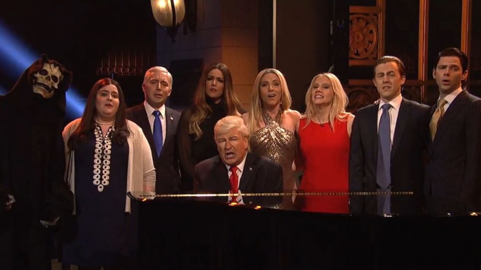 Alec Baldwin (sitting at the piano) as President Donald Trump, is flanked by (from far right) by Mikey Day as Donald Trump, Jr., Alex Moffatt as Eric Trump, Kate McKinnon as Kellyanne Conway, Scarlett Johansson as Ivanka Trump, Cecily Strong as Melania Trump, Beck Bennett as Mike Pence, Aidy Bryant as Sarah Huckabee Sanders, and a cast member in a Grim Reaper costume representing Steve Bannon, on "Saturday Night Live" on May 20, 2017.