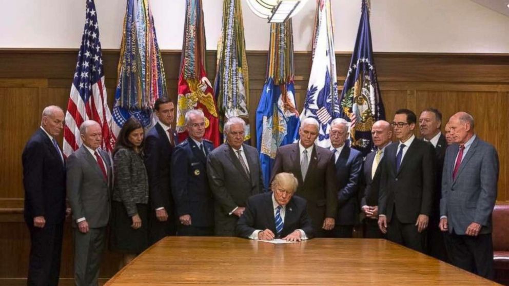 President Donald Trump, flanked by his cabinet members, signs on August 18, 2017 at Camp David the Global War on Terrorism War Memorial Act.