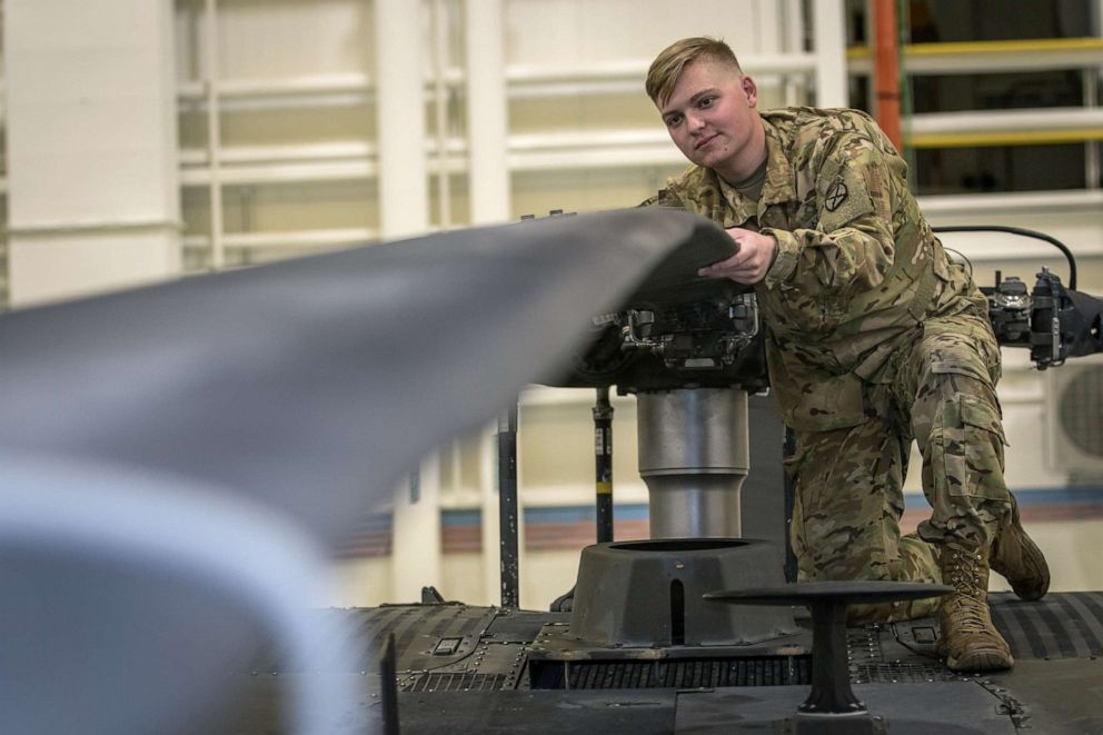 PHOTO: Army Pvt. Hunter Nines inspects UH-60L Blackhawk helicopter main rotor blades for signs of damage during routine helicopter inspections at Fort Drum, N.Y. on Oct, 4, 2019.