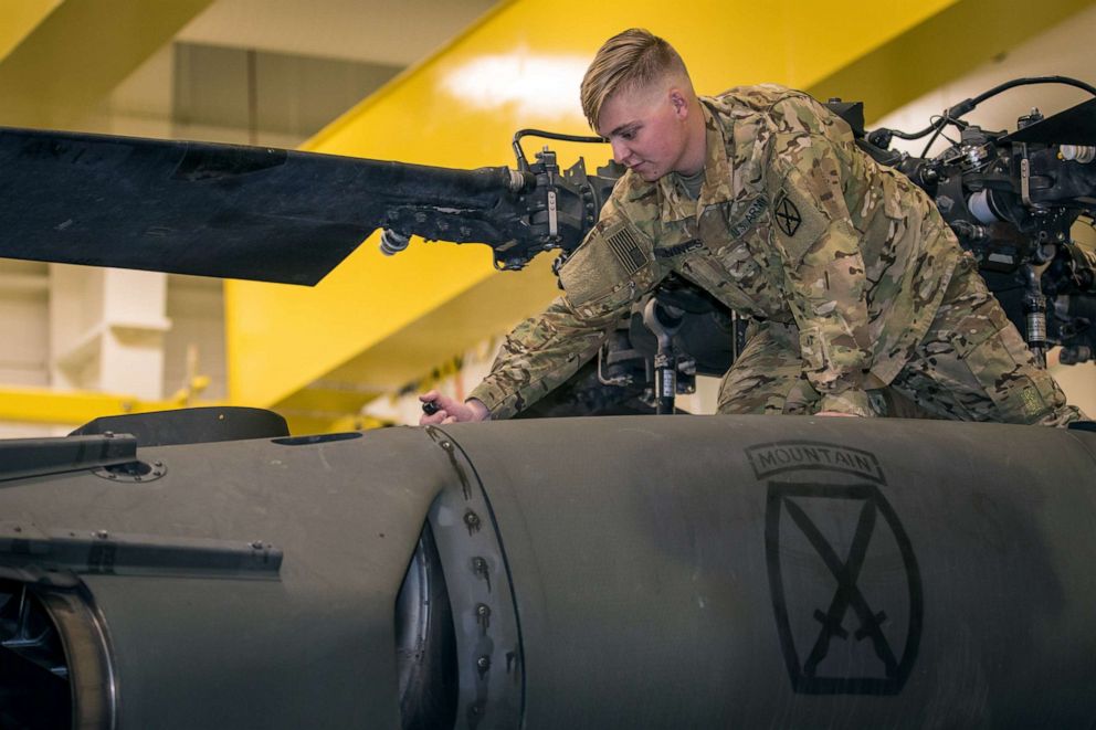 PHOTO: Army Pvt. Hunter Nines opens a UH-60L Blackhawk helicopter engine bay cowling to conduct fuel checks during routine inspections at Fort Drum, N.Y. on Oct. 4, 2019.