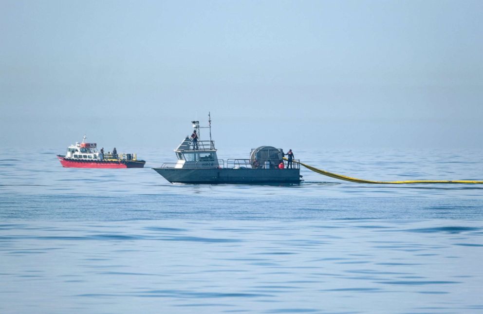 PHOTO: A Marine Spill Response Corporation (MSRC) vessel, foreground, an oil spill removal organization (OSRO), deploys floating barriers known as booms to try to stop further incursion of an oil slick off Huntington Beach, Calif., Oct. 3, 2021.