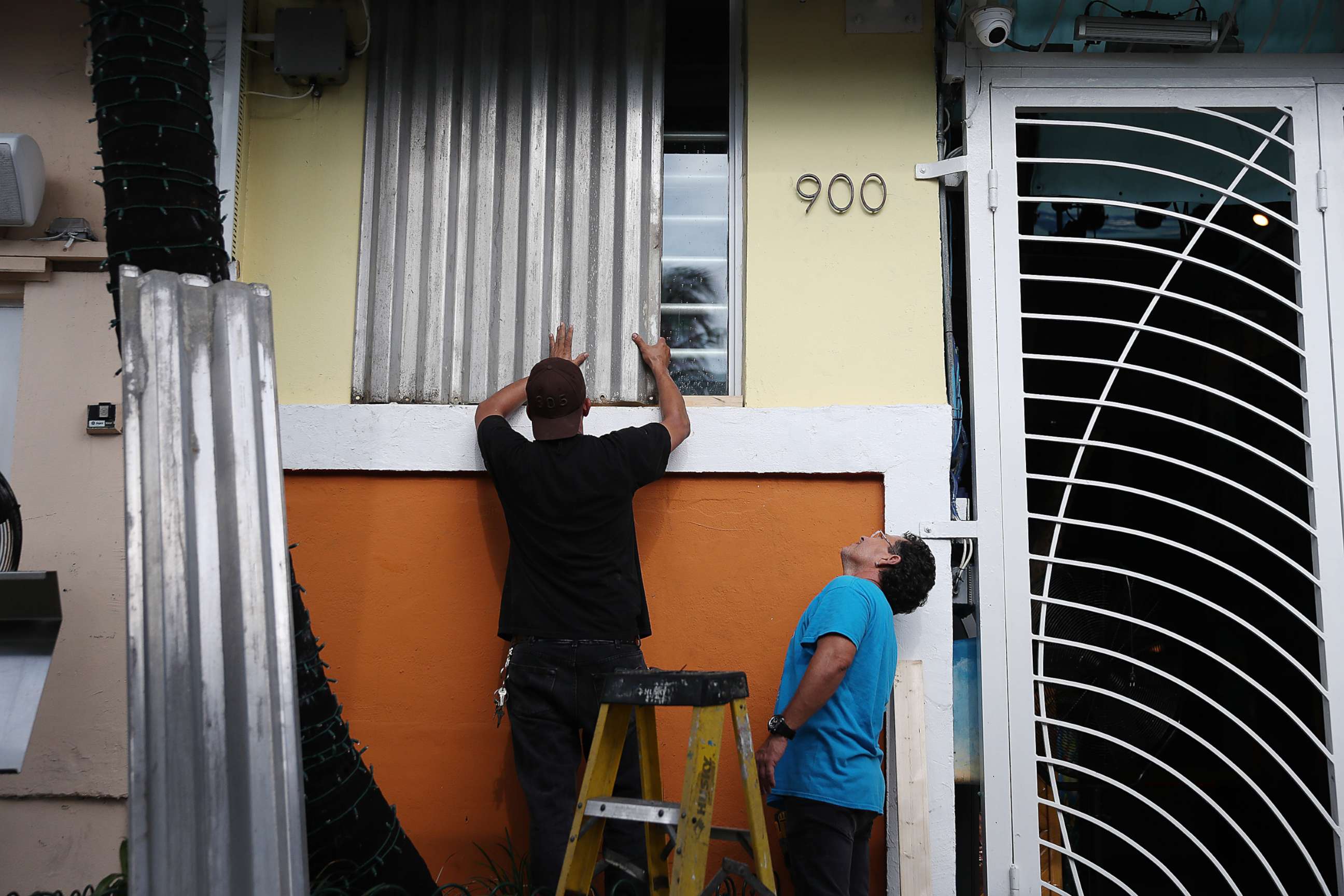 PHOTO: Workers place hurricane shutters over a window as they help prepare a business for the possible arrival of Hurricane Dorian on Aug. 30, 2019, in Miami Beach, Fla.