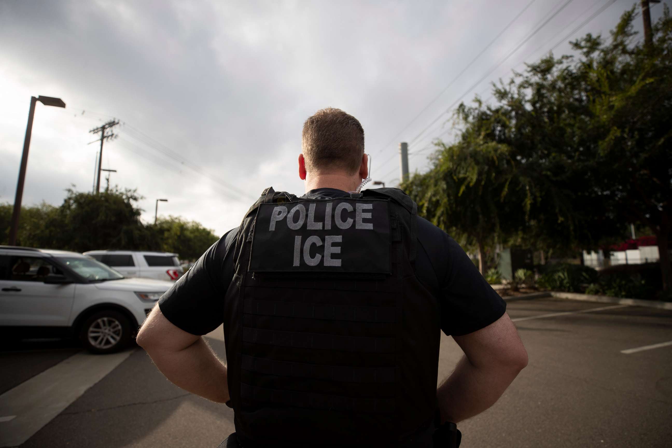 PHOTO: In this July 8, 2019, file photo, a U.S. Immigration and Customs Enforcement (ICE) officer looks on during an operation in Escondido, Calif.
