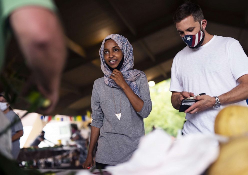 PHOTO: Rep. Ilhan Omar campaigns with her husband Tim Mynett, right, at the Richfield Farmers Market on Aug. 8, 2020 in Richfield, Minn.