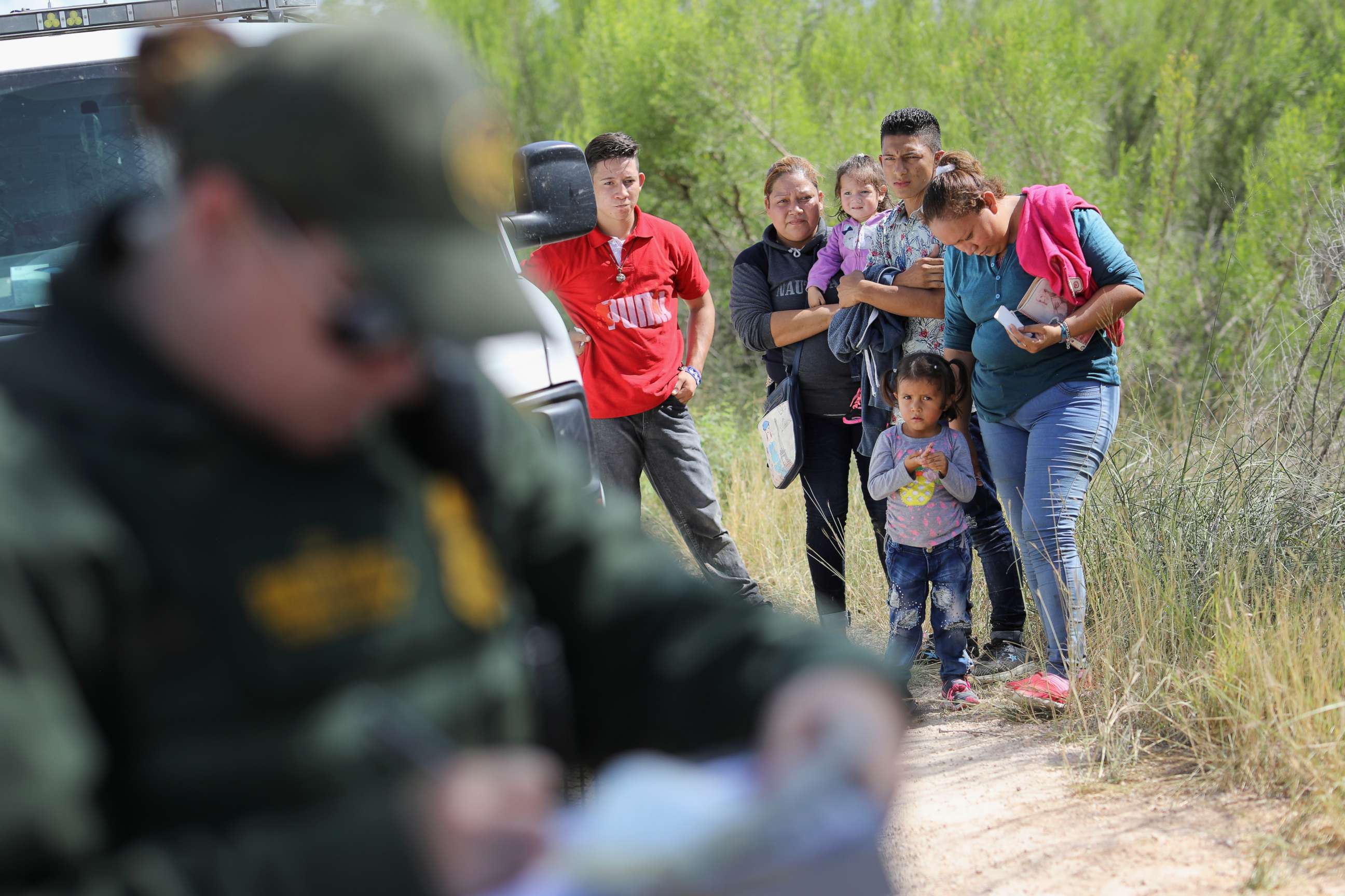 PHOTO: Central American asylum seekers wait as U.S. Border Patrol agents take groups of them into custody, June 12, 2018, near McAllen, Texas.
