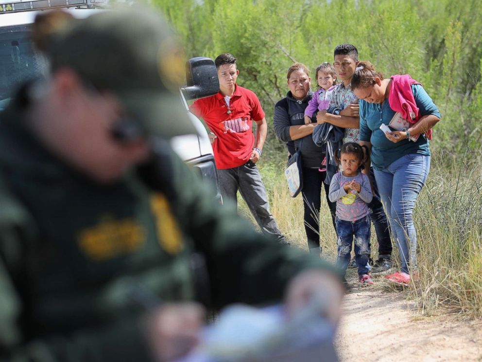 PHOTO: Central American asylum seekers wait as U.S. Border Patrol agents take groups of them into custody, June 12, 2018, near McAllen, Texas.
