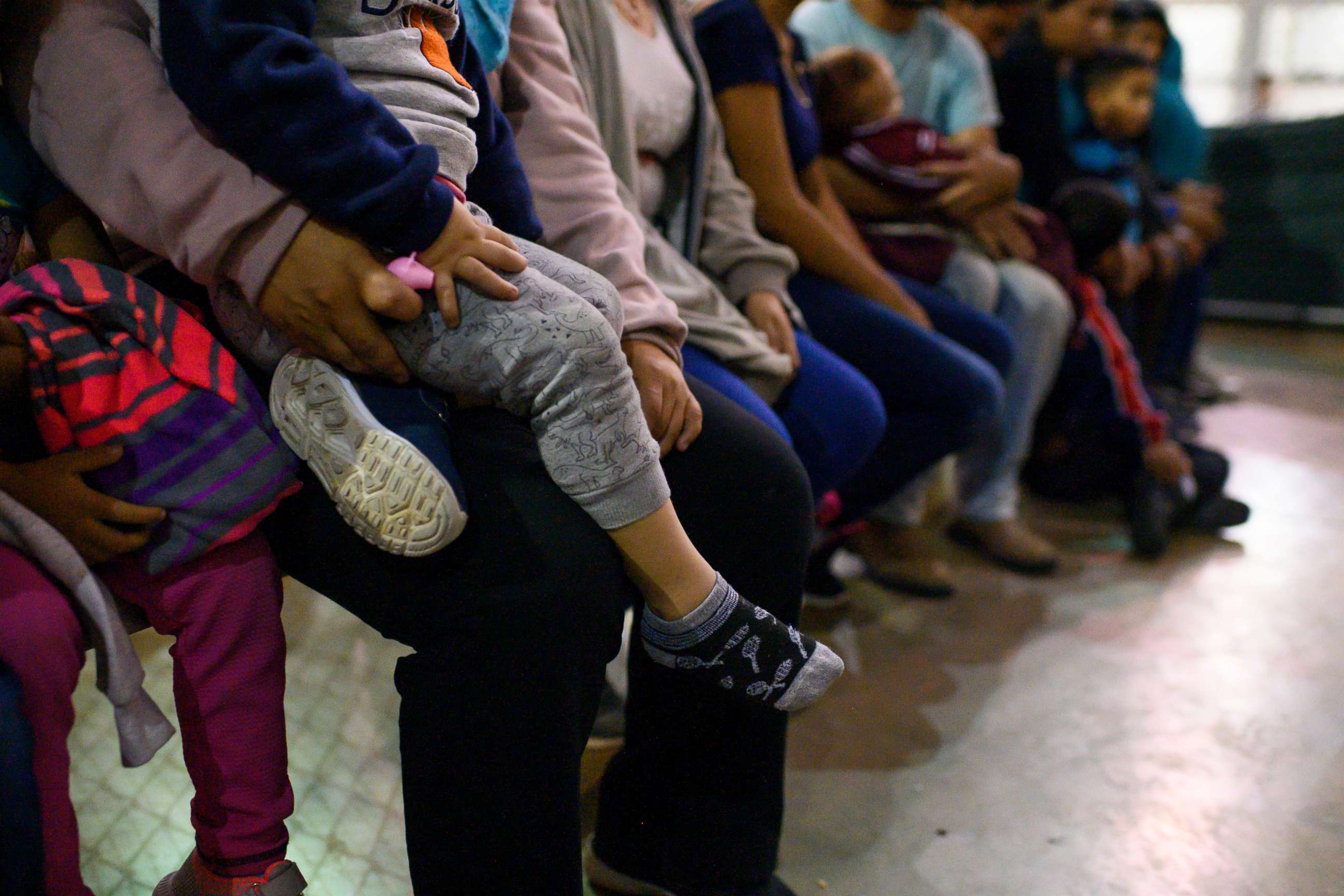 PHOTO: Recently detained migrants, many of them family units, sit and await processing in the US Border Patrol Central Processing Center in McAllen, Texas on August 12, 2019.