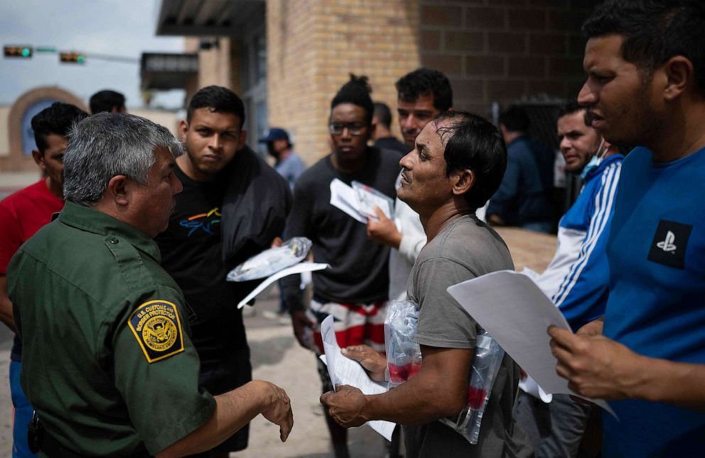 PHOTO: A Border Patrol agent speaks with migrants after they got off a bus at a processing center, May 11, 2023, in Brownsville, Texas.