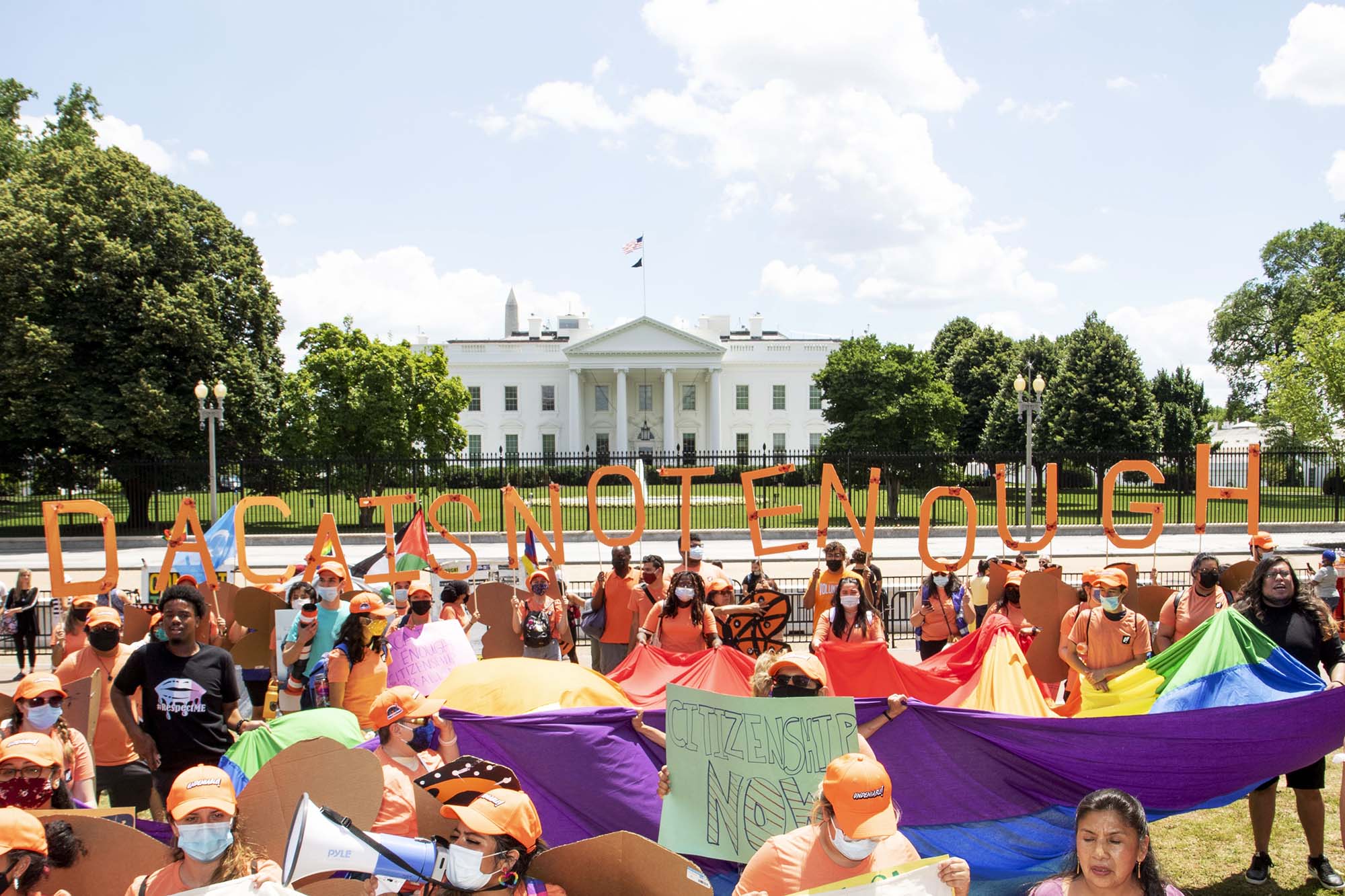 PHOTO: Protesters holding a sign that reads "DACA Is Not Enough" stand in front of the White House at a DACA rally in Lafayette Square Park in Washington, June 15, 2021.