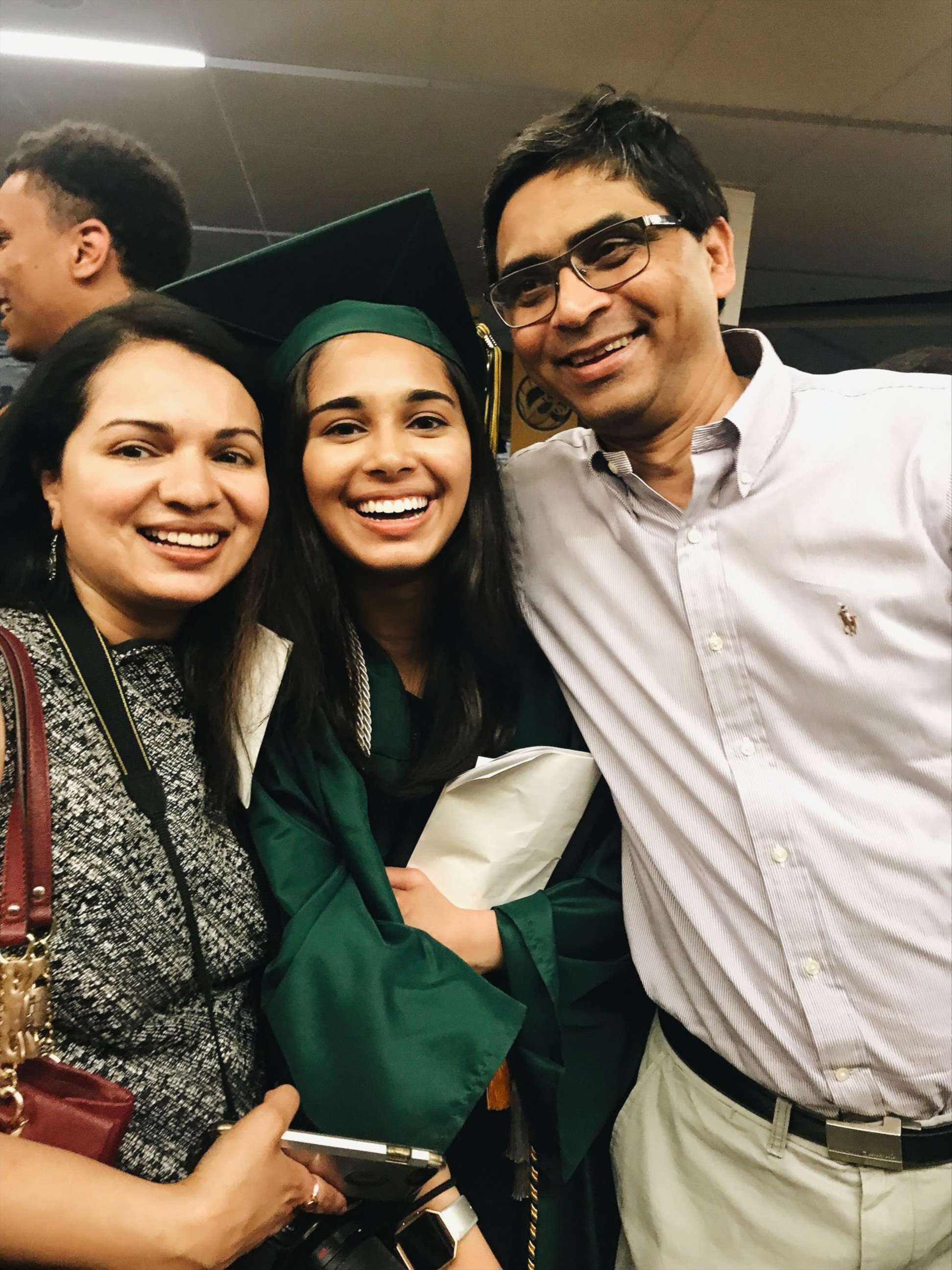 PHOTO:  Pareen Mhatre, center, with her parents in an undated family photo of her high school graduation in Iowa City, Iowa.