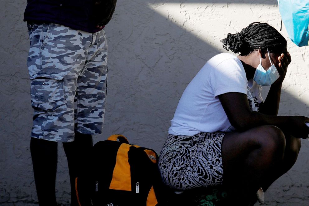 PHOTO: A woman reacts as she waits in line with other migrants seeking asylum in the U.S. to board a bus to Houston from Val Verde Border Humanitarian Coalition after being released from U.S. Customs and Border Protection, Del Rio, Texas, Sept. 24, 2021.