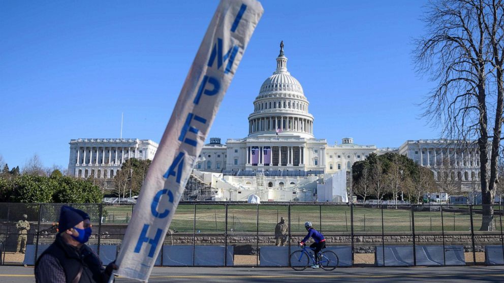 PHOTO: A protester carries a sign calling for Congress to impeach President Donald Trump, near the U.S. Capital in Washington on Jan. 10, 2021.