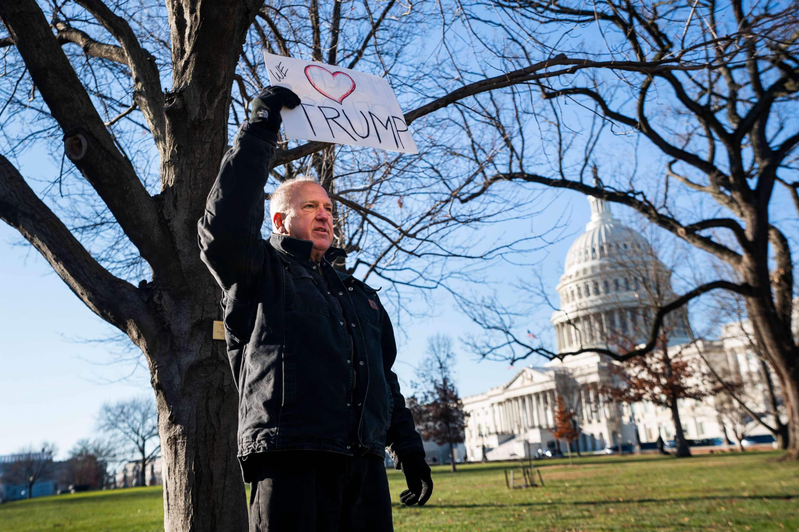 PHOTO: A lone Trump supporter holds a sign in support of the President outside the Capitol in Washington, Dec. 18, 2019.